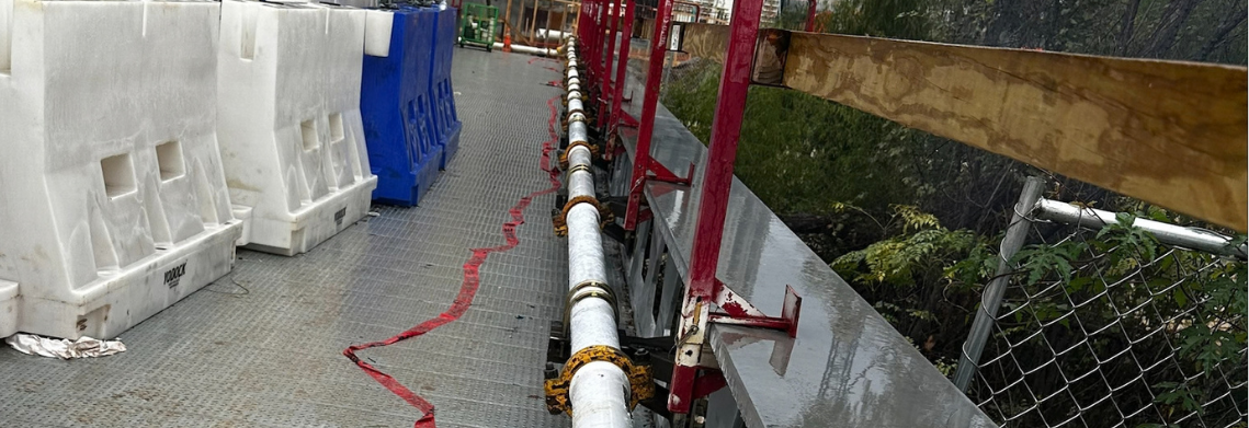 Concrete pump line along an access walkway on a commercial site