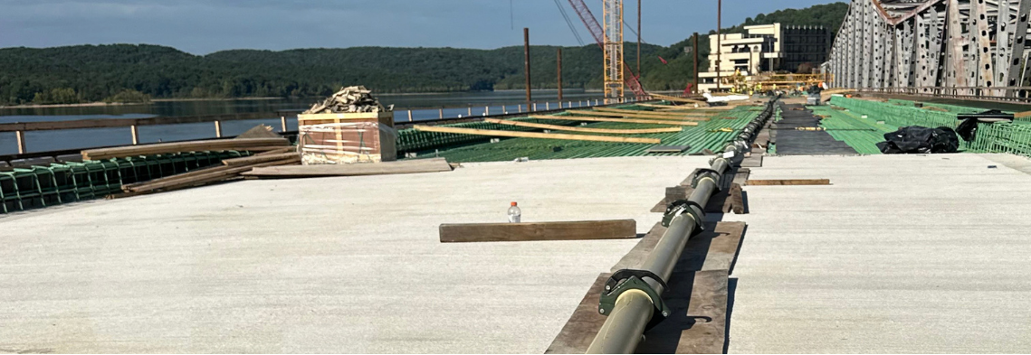 Concrete pump line running along a bridge deck